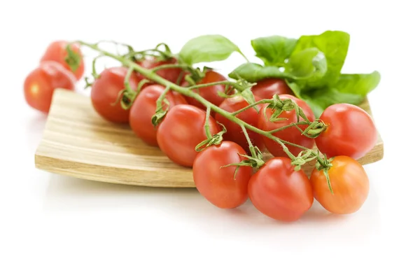 Fresh tomatoes on wooden plate — Stock Photo, Image