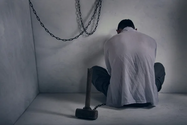 Wanhopig gevangene in een grijze kamer. — Stockfoto