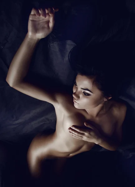 Drömmer naken tjej i mörka skuggor Stockfoto