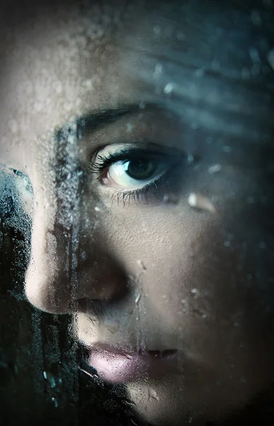 Ung flicka tittar genom fönstret — Stockfoto