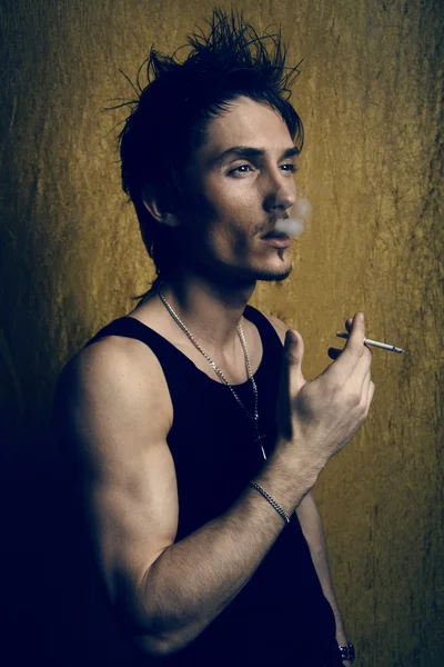 Retrato del joven fumador sobre un oro — Foto de Stock