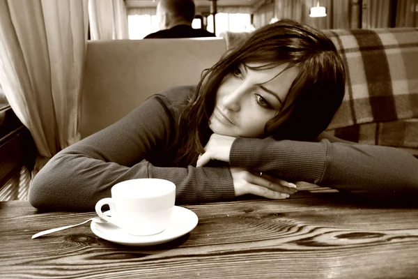 Aantrekkelijke vrouw zit aan tafel in koffie — Stockfoto