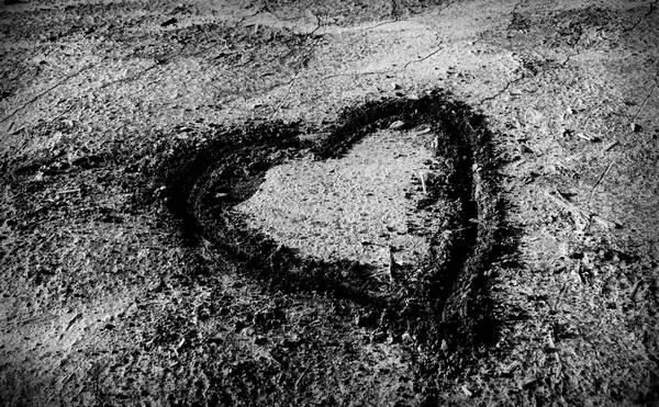 Heart emblem drawn on dried up sand — Stock Photo, Image