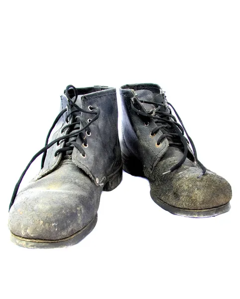 Velhas botas sujas em um fundo branco — Fotografia de Stock