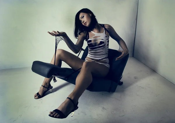 A menina sexual sentada em uma poltrona — Fotografia de Stock