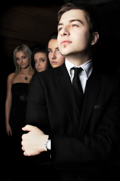 Elegante hombre y tres mujeres detrás de él . — Foto de Stock