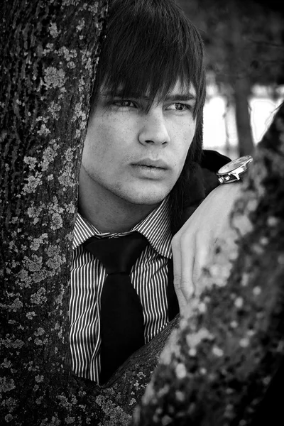 屋外の木の近くの悲しいスタイリッシュな男。写真 — ストック写真
