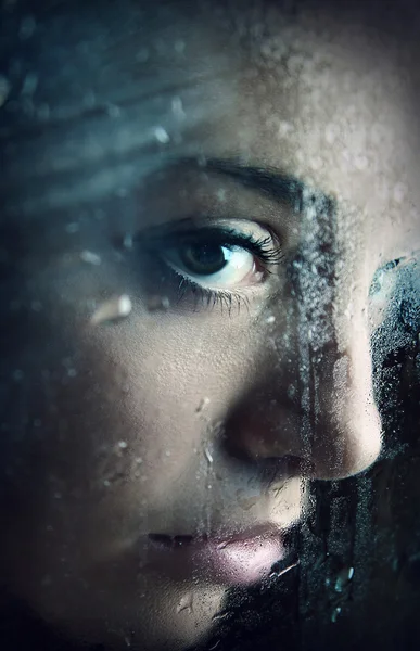 Junges Mädchen schaut durch Fenster — Stockfoto