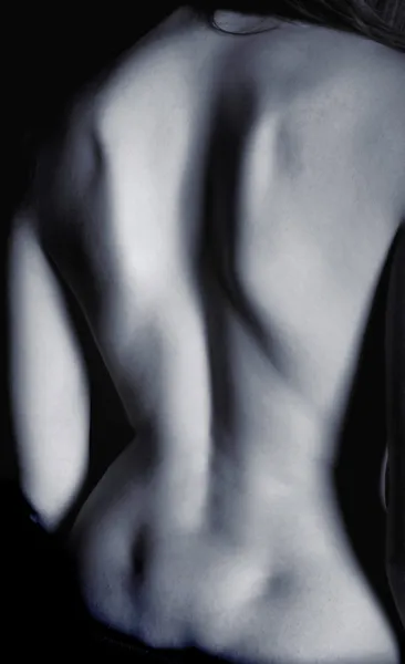 Slim feminino de volta em iluminação estúdio escuro — Fotografia de Stock
