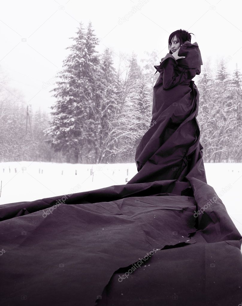 Girl in a long black dress standing