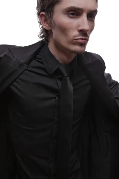 Junger Macho im schwarzen Anzug auf weißem Hintergrund — Stockfoto