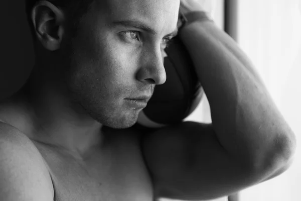 Jovem macho atraente olhando na janela — Fotografia de Stock