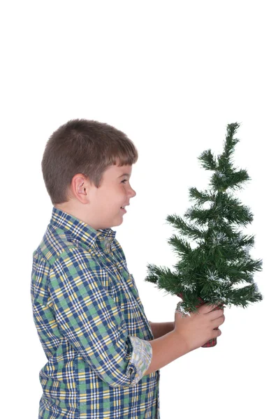 O rapaz mantém em uma mão uma árvore de pele de Natal — Fotografia de Stock
