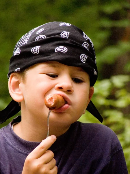 Chłopiec zjada kiełbasa — Zdjęcie stockowe