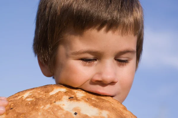 Kleiner Junge beißt Brot — Stockfoto