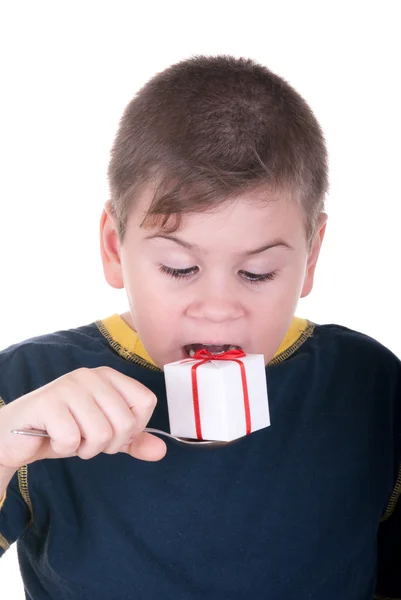 Хлопчик кусає подарунок на ложці — стокове фото