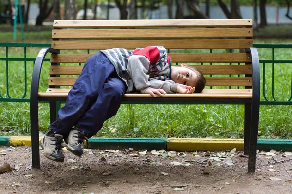 Мальчик лежит на скамейке — стоковое фото