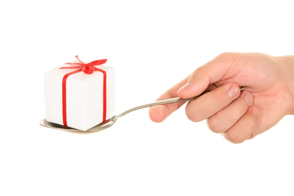 Hand holds gift on spoo — Stock Photo, Image