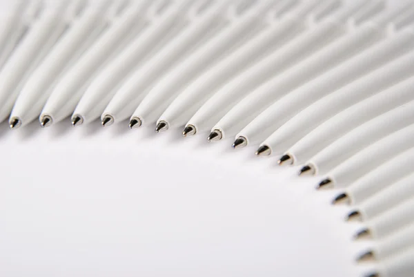 Einige weiße Kugelschreiber liegen im Halbkreis — Stockfoto
