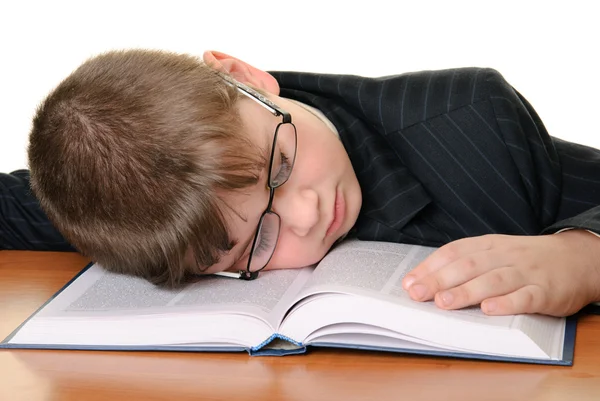 Chlapec v brýlích spí na knihu — Stock fotografie