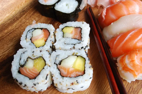 Sushi - japanisches Essen (auf einem Holzteller) — Stockfoto