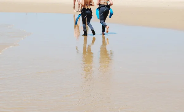Unga surfare promenerar på stranden — Stockfoto