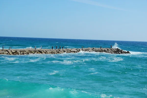 Rock cena de pesca em um oceano ondulado — Fotografia de Stock