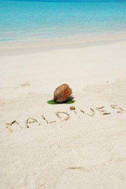 Maldives written in a sandy tropical bea clipart