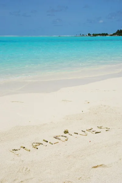 Мальдивы, написанные на песчаной тропической плите — стоковое фото