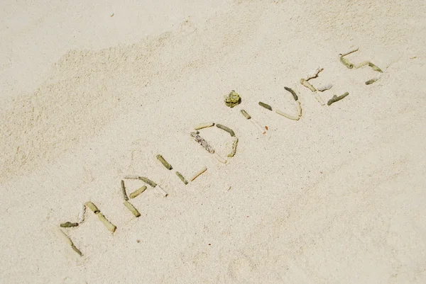 Мальдивы, написанные на песчаной тропической плите — стоковое фото