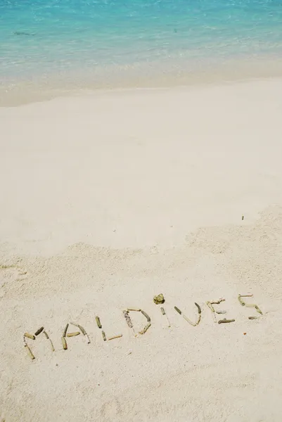 Malediven in einer sandigen tropischen Bohne geschrieben — Stockfoto