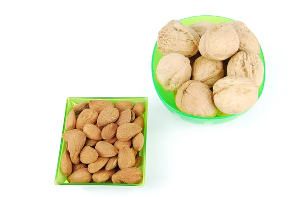 Миндаль и грецкие орехи на зеленой чашке — стоковое фото