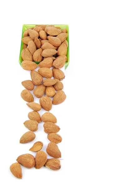 Scattered almond nuts on a cup — Stock Photo, Image