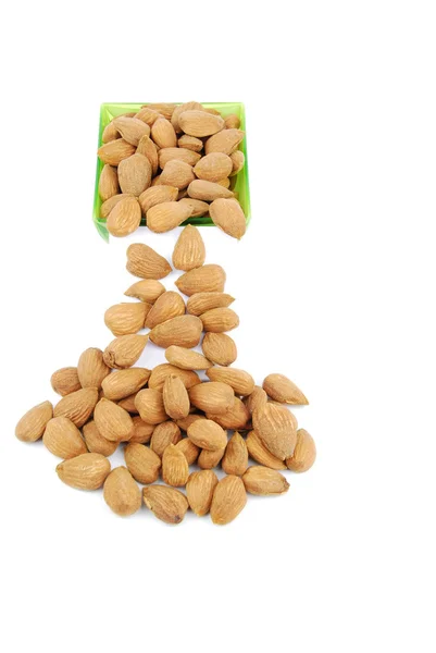 Scattered almond nuts on a cup — Stock Photo, Image
