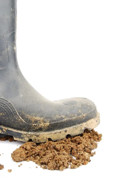 Černý gumový boot a půdy na bílém pozadí — Stock fotografie