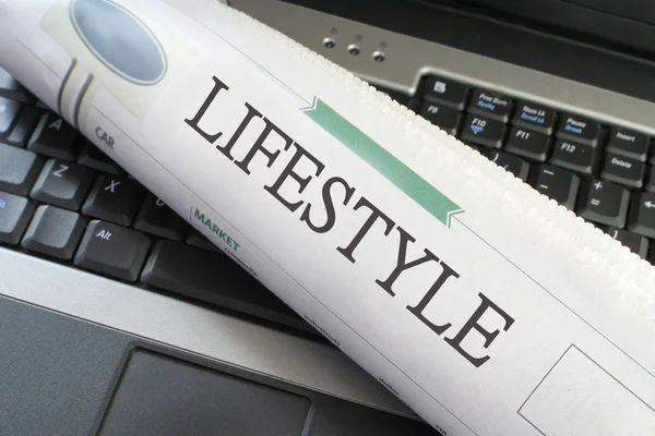 Lifestylová část novin na laptop — Stock fotografie