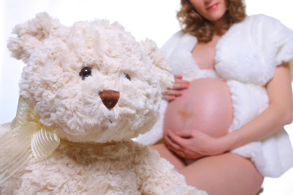 Беременная женщина и плюшевый мишка — стоковое фото