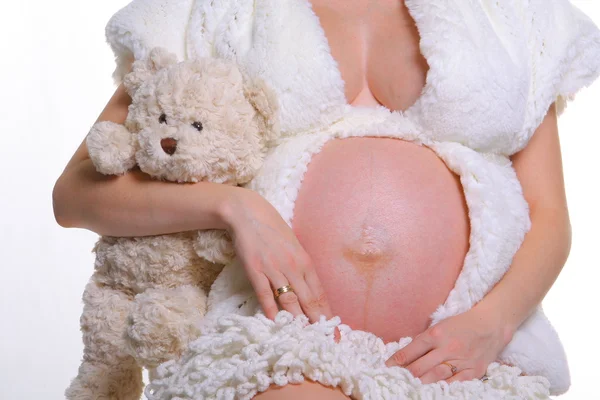 Mujer embarazada y oso de peluche Fotos de stock libres de derechos