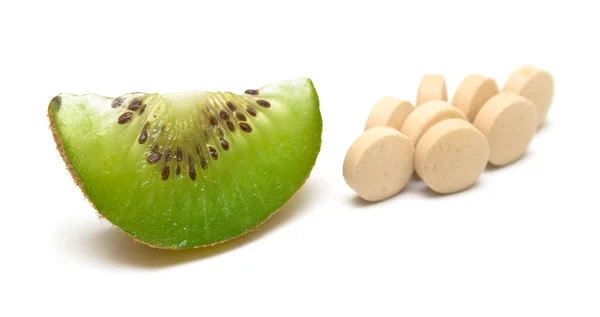 Kiwi and a handful of tablets — Stock Photo, Image