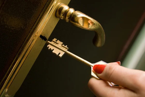 Hand, Schlüssel und Eisentür verriegeln Stockbild
