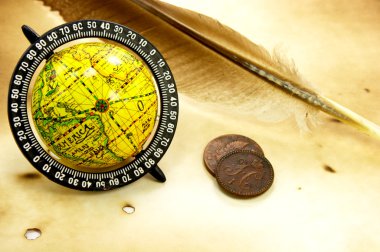 Old globe, feather and coins clipart