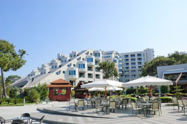 Hotel building with open air cafeteria, clipart