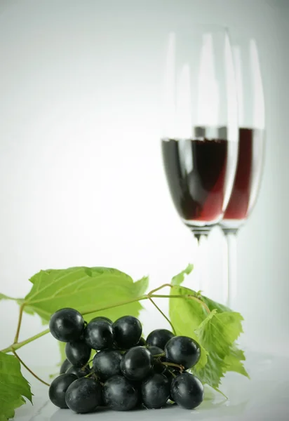 stock image Black grapes and tall wine glasses