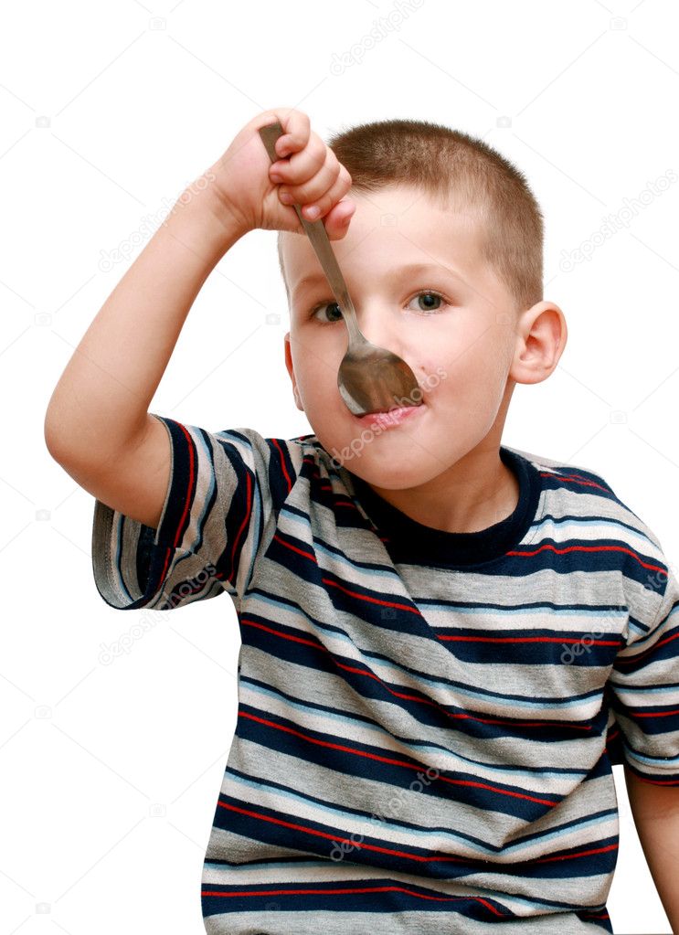 Little boy with a spoon in mouth