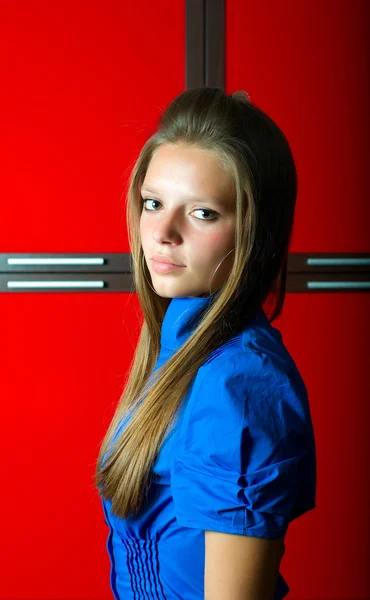 Girl in blue at red background — Stok Foto