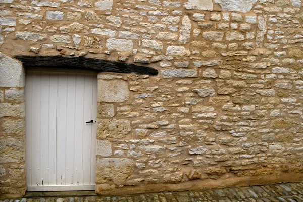 Beyaz kapı ile eski sarı taş duvar — Stok fotoğraf