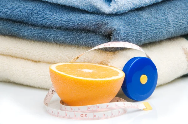 Pile of towels and half of orange — Stock Photo, Image