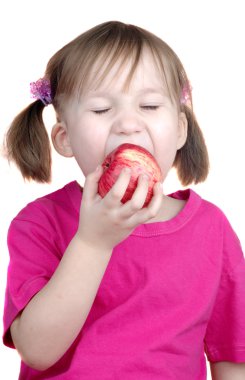 Küçük kız elma yiyor.