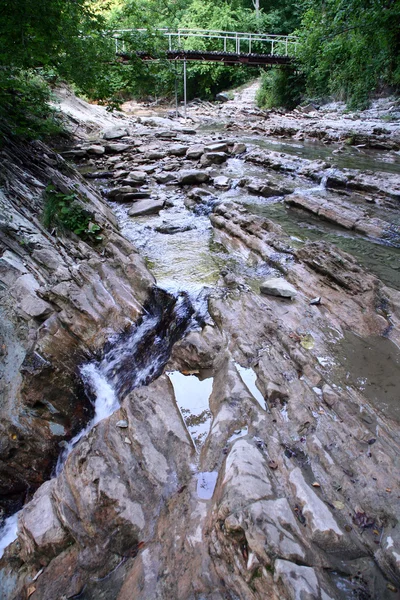 Small mountain river flows under bridge — Stock Photo, Image