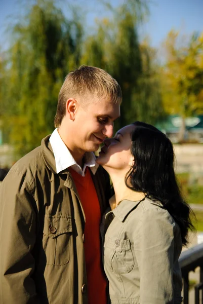 Young woman whispers to mans ear — Stock Photo, Image